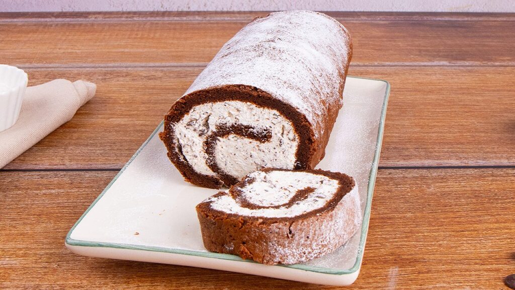 Il rotolo al cioccolato è un dolce soffice e goloso: una morbida pasta biscotto al cacao farcita