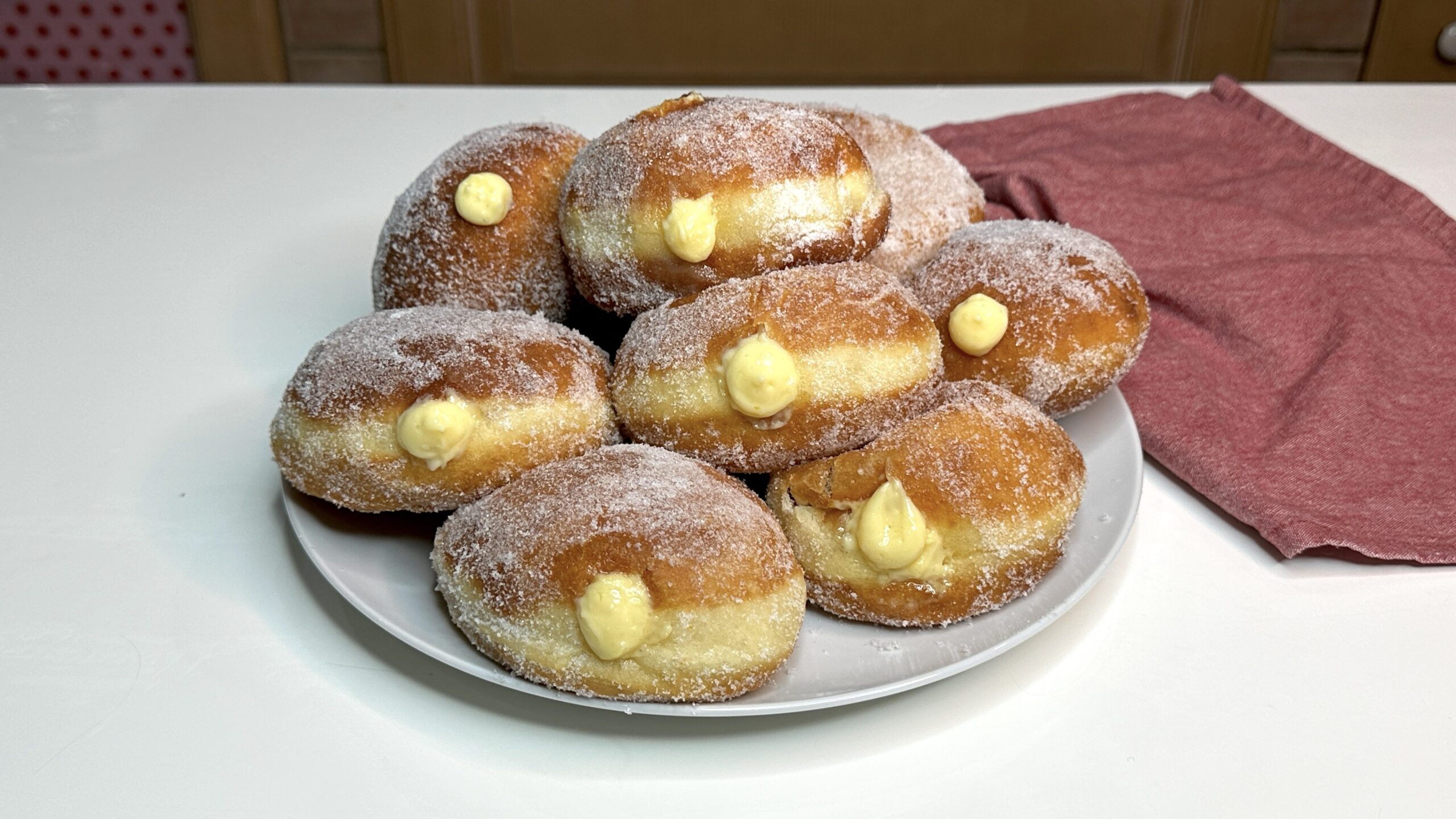 I bomboloni sono dei dolci fritti ricoperti di zucchero semolato e ripieni con crema pasticciera